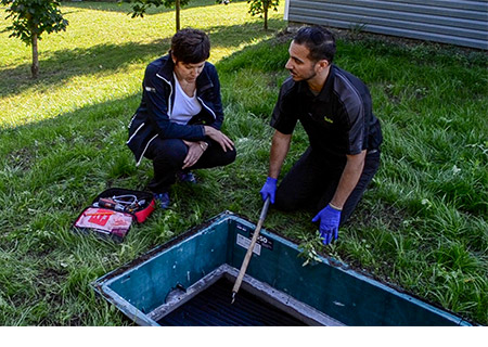 Premier Tech’s local service technician explaining Ecoflo biofilter septic system maintenance to a customer.