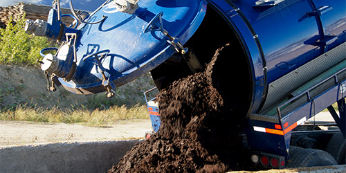Camion vacuum qui décharge le milieu filtrant compostable recueilli dans les installations septiques écoresponsables Ecoflo.