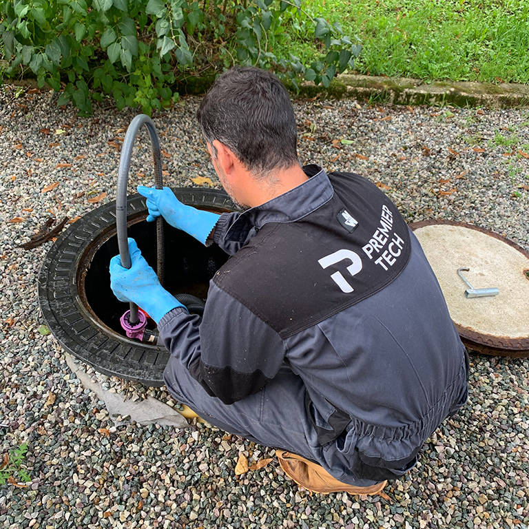 Premier Tech Water and Environment technician inspecting and wiring a wastewater treatment system in Ireland.