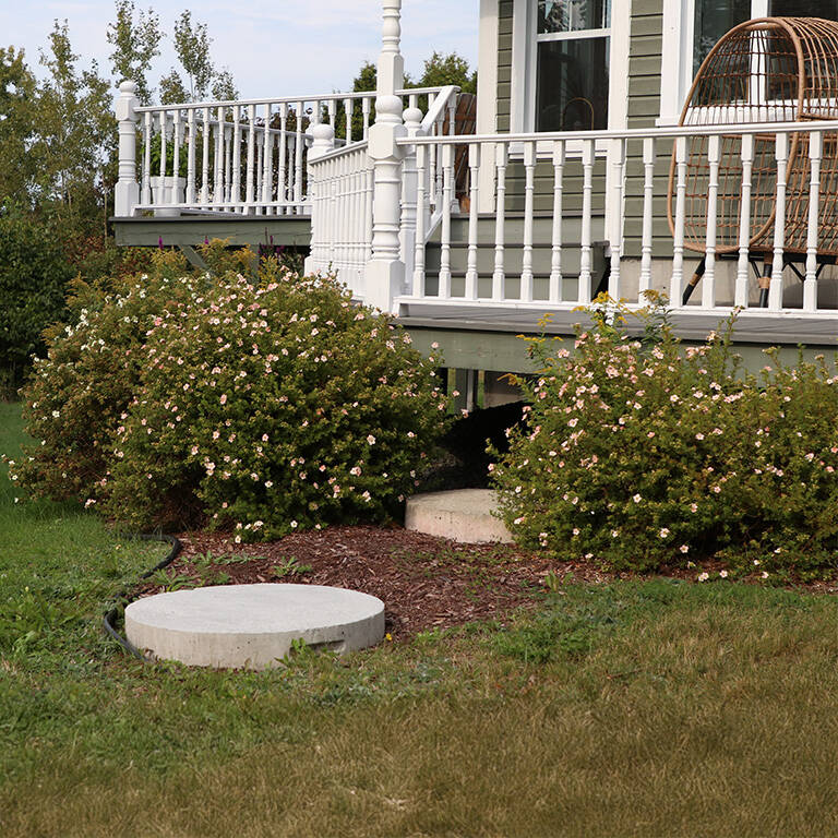 Septic tank lids in front of a rural property.